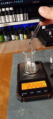 Dosing a scent material onto a scale with a pipette